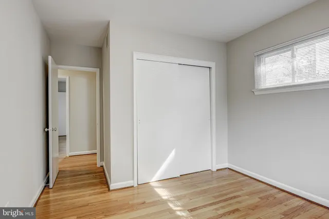 an empty room with wooden floor and a window