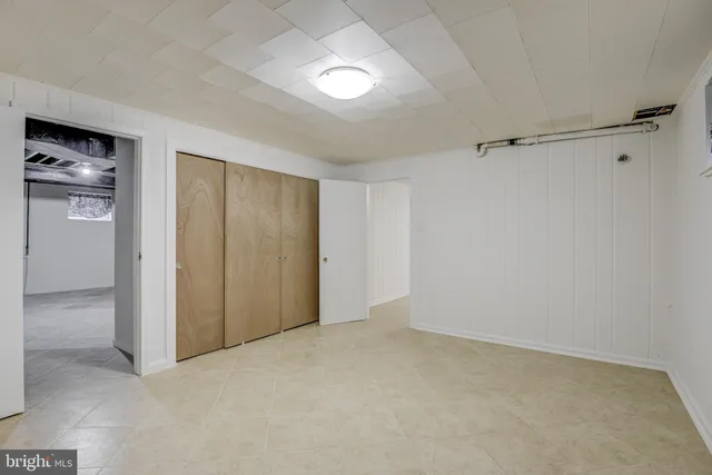 an empty room with fireplace and a hallway