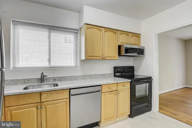 a kitchen with stainless steel appliances a sink stove top oven and refrigerator