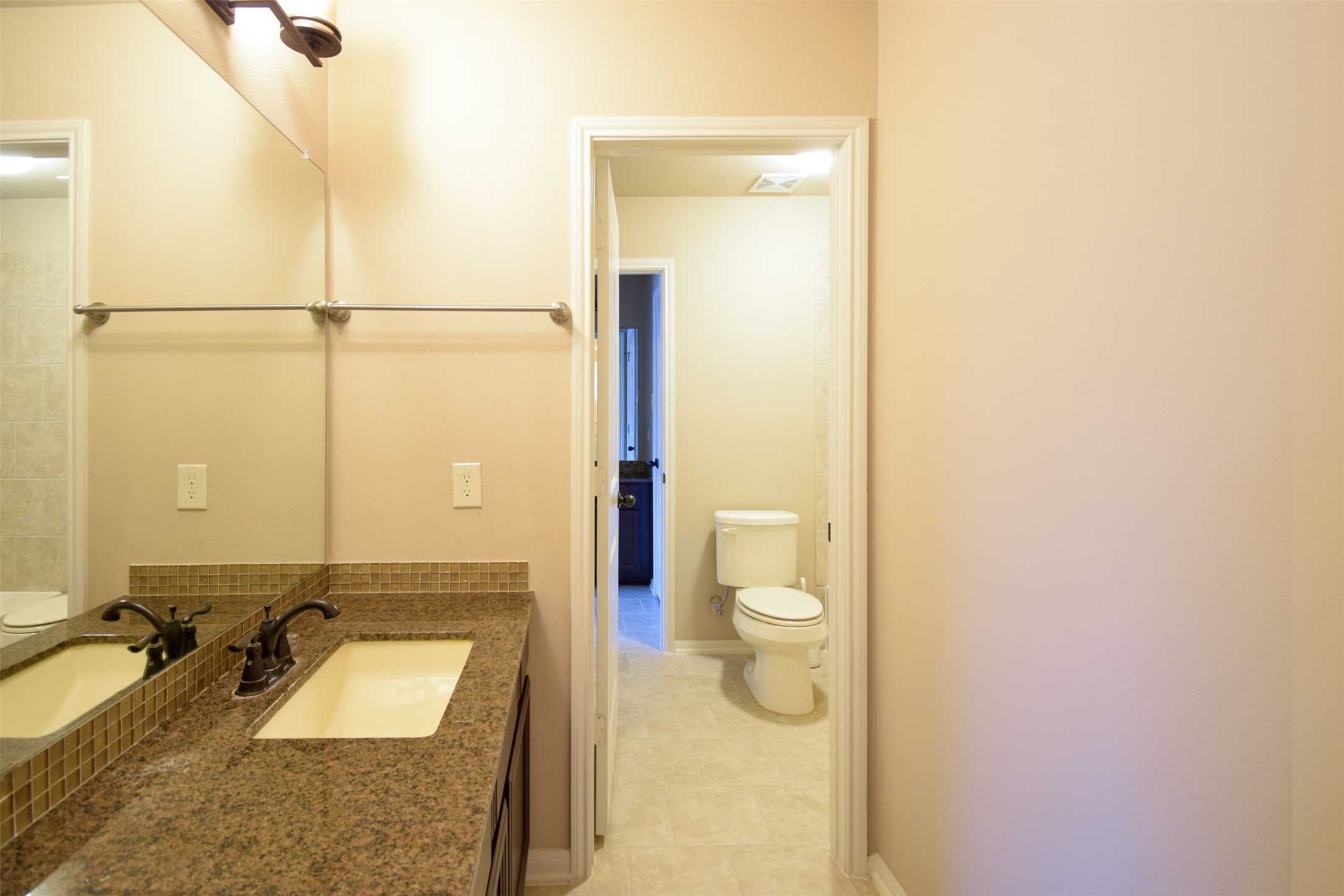 27363 Pendleton Trace Drive Spring, TX 77386 - Photo 22 of 26 a bathroom with a granite countertop sink a toilet and a mirror