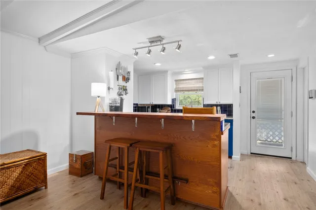 a room with stainless steel appliances kitchen island granite countertop furniture and a refrigerator