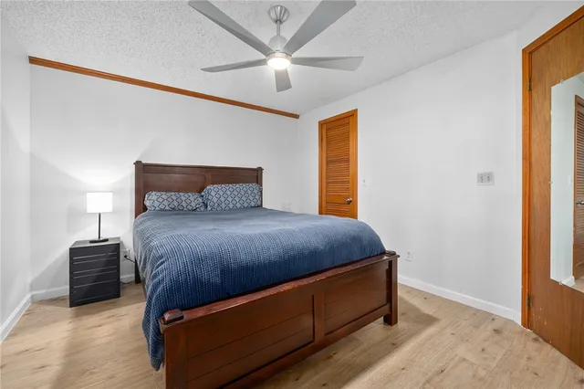 a bedroom with a bed and a ceiling fan