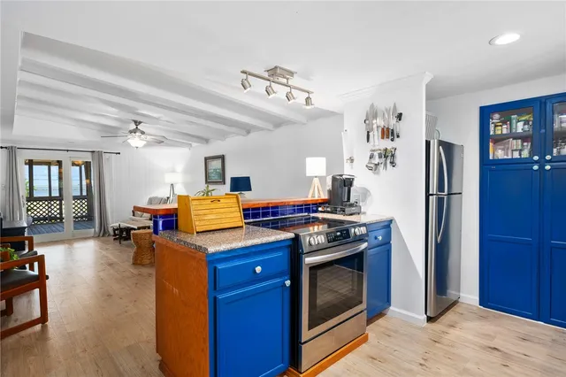 a kitchen with stainless steel appliances granite countertop a refrigerator a stove and a dining table