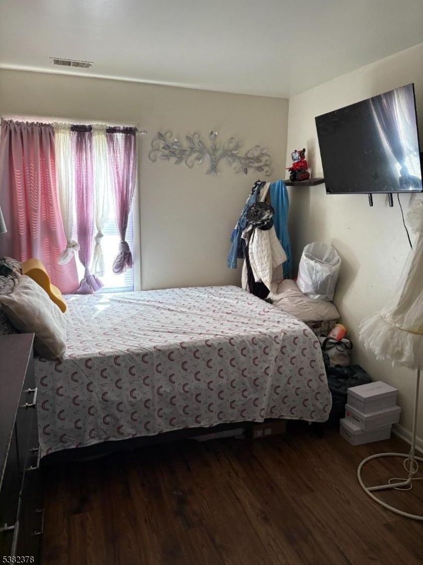 49 Hope Street Passaic, NJ 07055 - Photo 8 of 9 a bedroom with a bed and a flat tv screen on the dresser