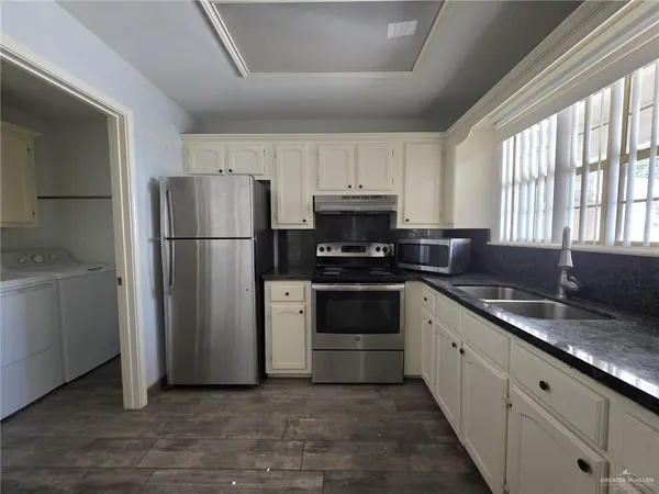 a kitchen with a refrigerator sink and cabinets
