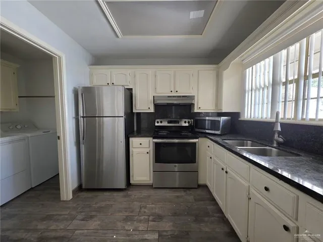 a kitchen with a refrigerator sink and cabinets