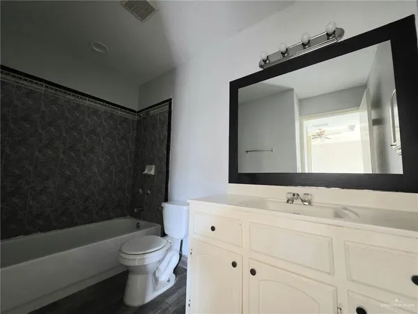 a bathroom with a sink toilet a mirror and bathtub