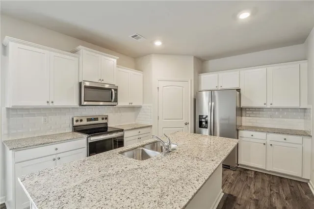a kitchen with stainless steel appliances granite countertop a sink stove and refrigerator