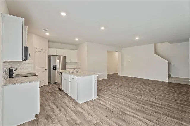 a large white kitchen with a sink a refrigerator and a stove