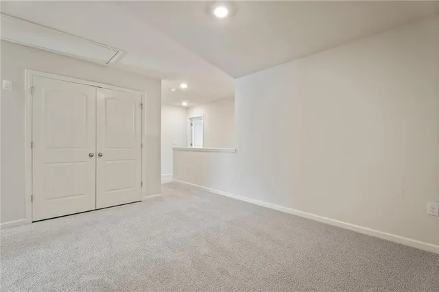 an empty room with white cabinet and windows