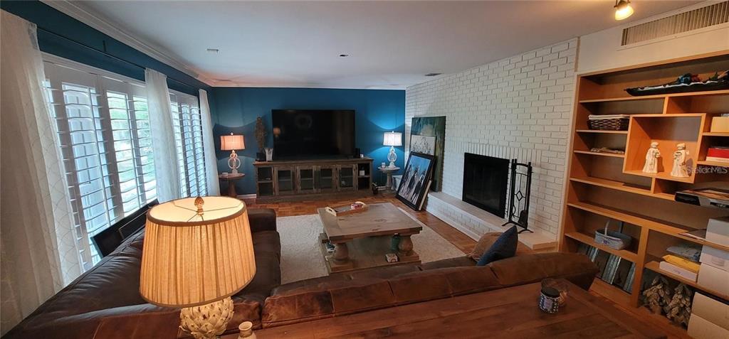 11129 Lake Butler Boulevard Windermere, FL 34786 - Photo 9 of 17 a living room with furniture flat screen tv and a fireplace