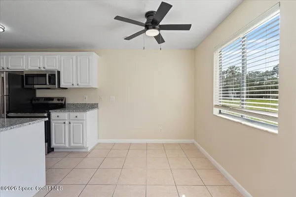 a kitchen with a stove a microwave and white cabinets