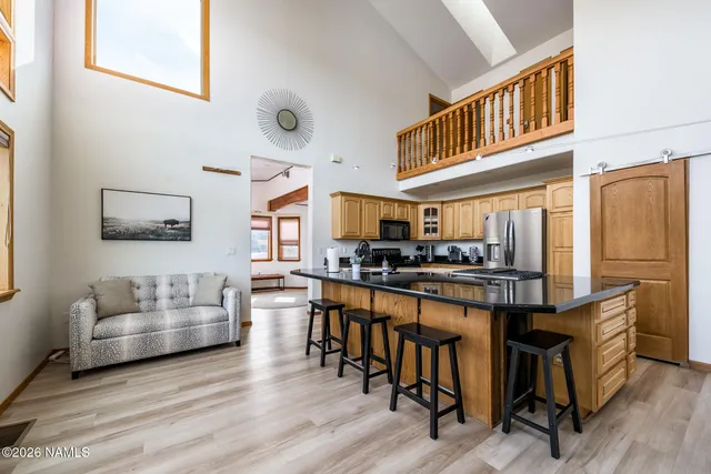a living room with stainless steel appliances furniture a fireplace and a large window