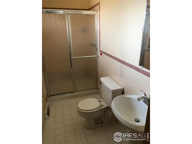 a white toilet sitting next to a bathroom sink and a shower