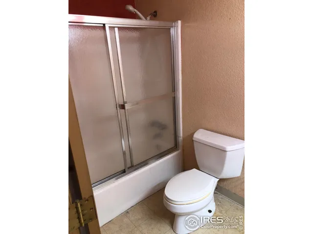 a white toilet sitting next to a shower