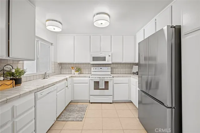 a kitchen with white cabinets and white appliances