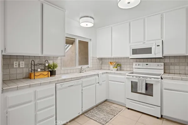 a kitchen with cabinets stainless steel appliances and a counter space