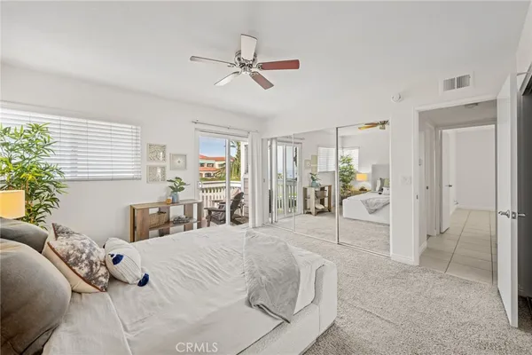 a bedroom with a large bed and ceiling fan