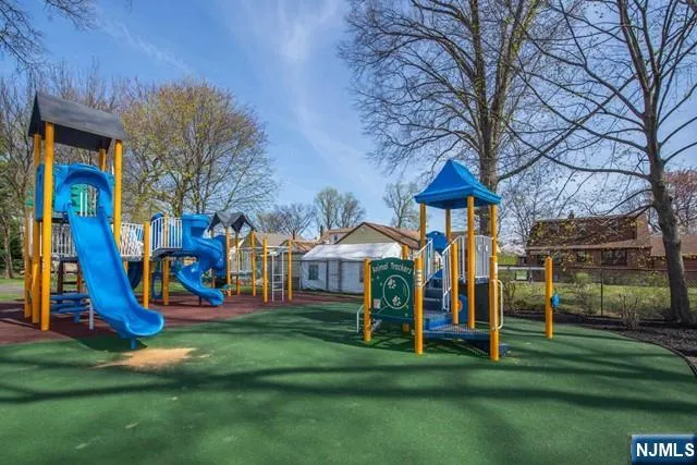 a view of a park with slide and a bench