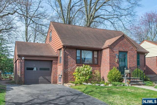 153 Madison Avenue Rochelle Park, NJ 07662 - Photo 12 of 26 a front view of a house with a yard and garage