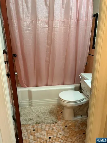 a bathroom with a toilet and a shower curtain