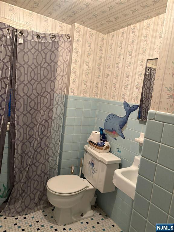 153 Madison Avenue Rochelle Park, NJ 07662 - Photo 16 of 26 a bathroom with a toilet sink and shower curtain