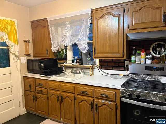 a kitchen with stainless steel appliances granite countertop a sink stove and cabinets