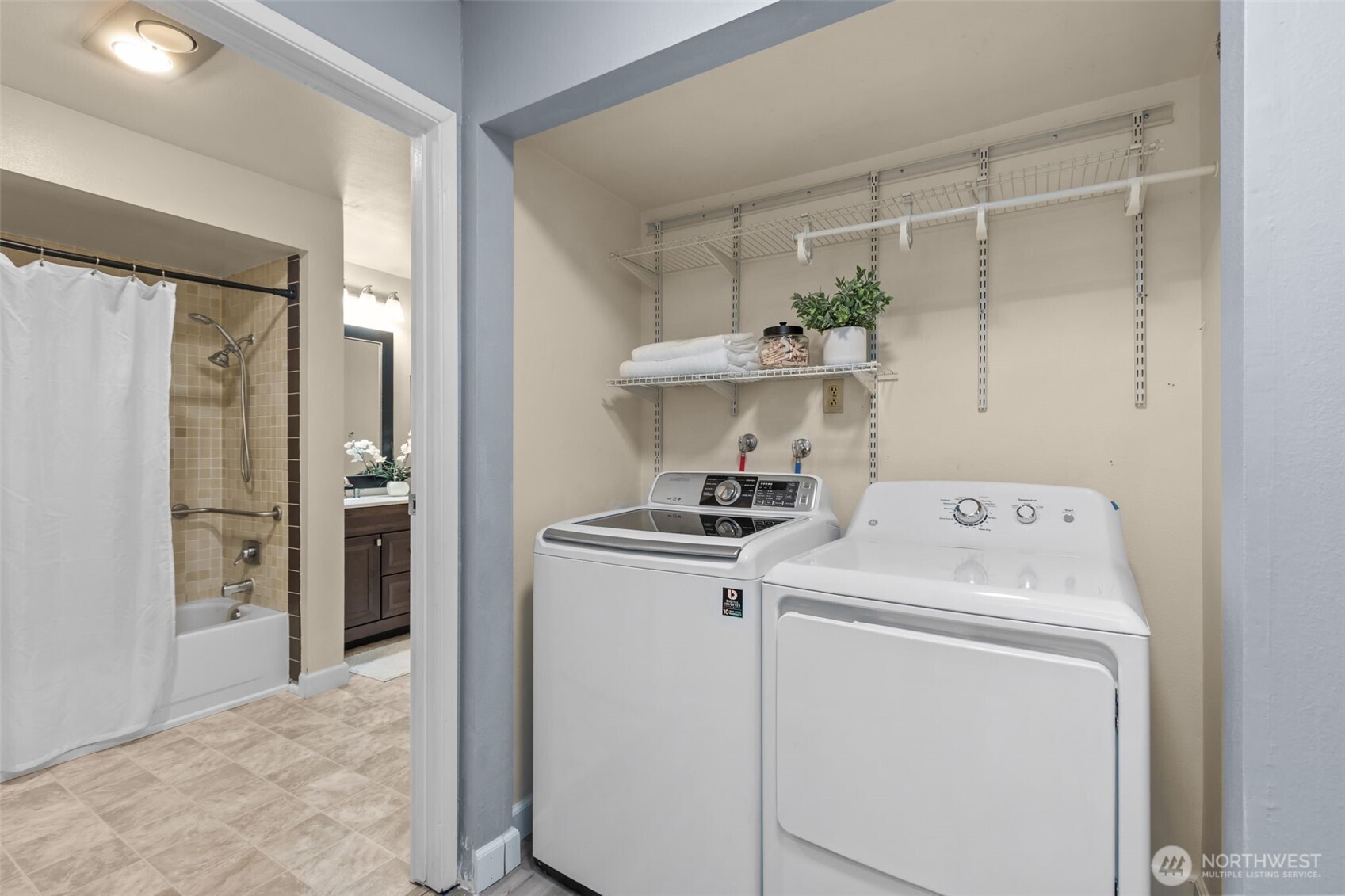 2001 East Yesler Way, Unit 46 Seattle, WA 98122 - Photo 13 of 20 a view of washer and dryer with kitchen in the background