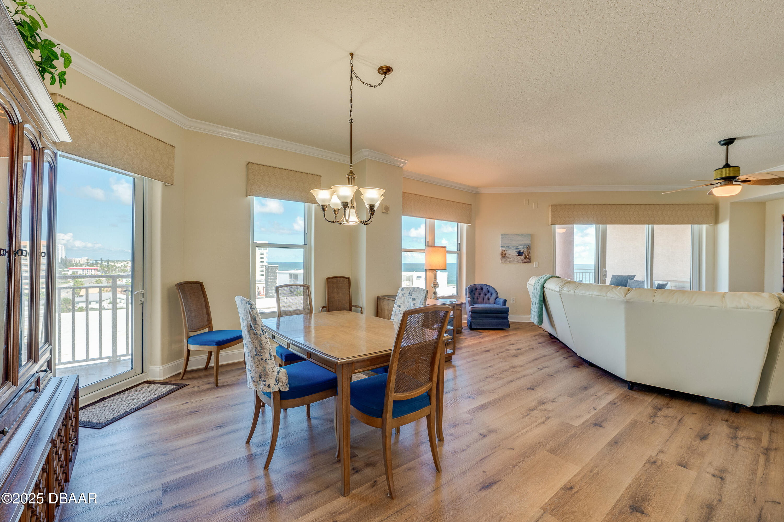 3245 South Atlantic Avenue, Unit 601 Daytona Beach, FL 32118 - Photo 12 of 48 a dining room with furniture a chandelier and wooden floor