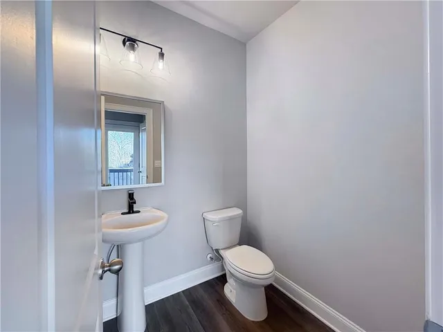 a bathroom with a toilet a sink and mirror