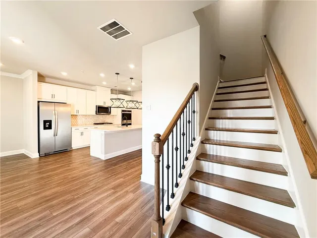 a view of a kitchen with wooden floor and electronic appliances