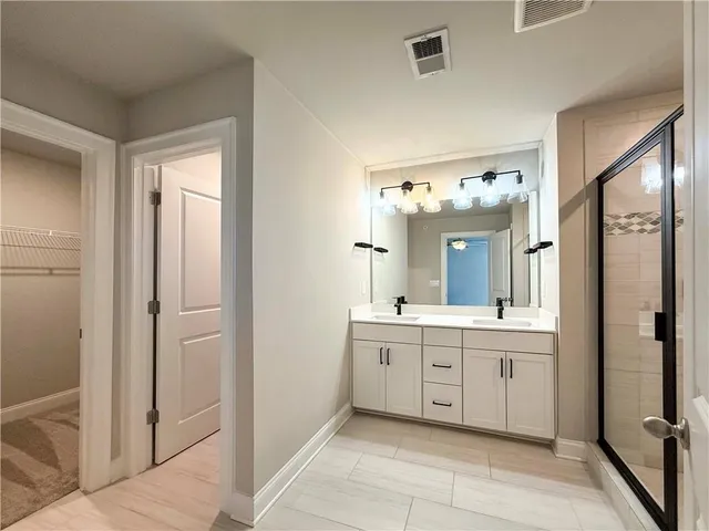 a spacious bathroom with a double vanity sink a mirror and a bathtub