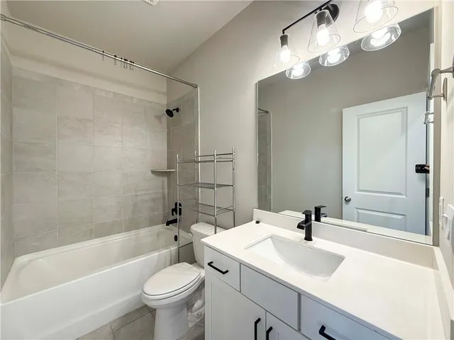 a bathroom with a sink a toilet a mirror a bathtub and shower