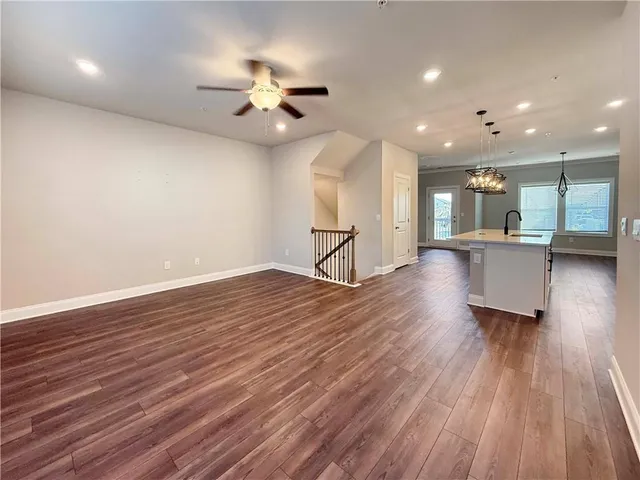 an empty room with wooden floor and chandelier