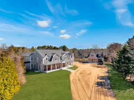 a view of a house with a big yard with large trees