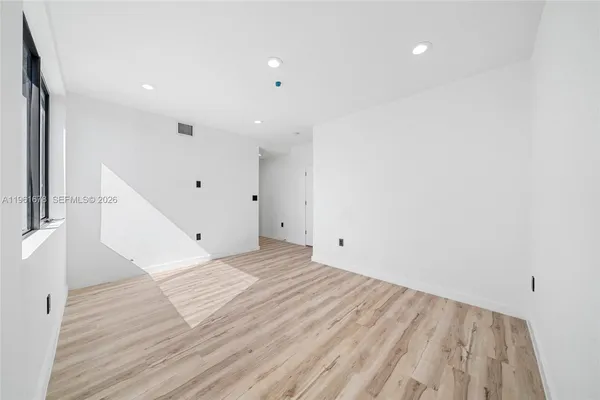 a view of empty room with wooden floor