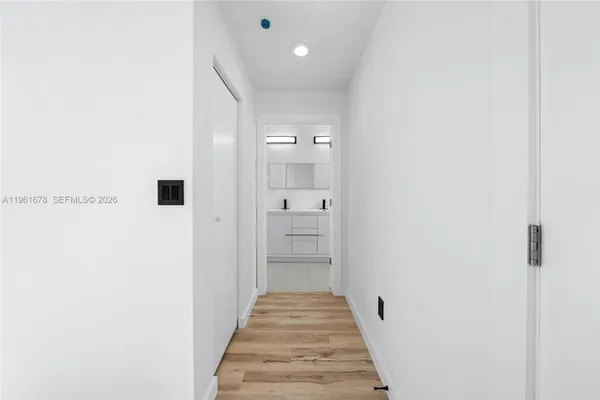 a view of a hallway with wooden floor and staircase