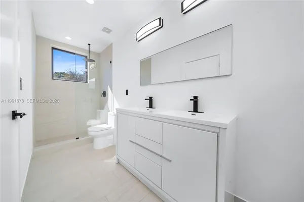 a bathroom with a sink mirror and toilet