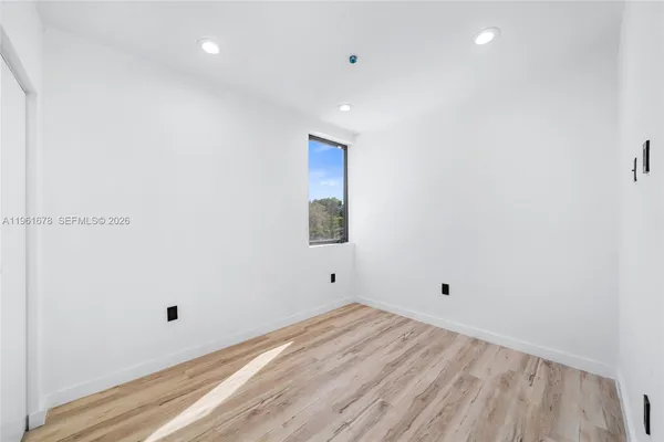 a view of empty room with wooden floor
