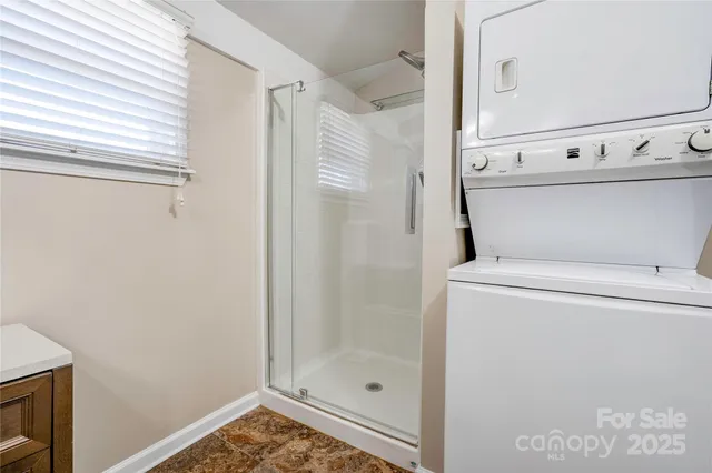 a bathroom with a granite countertop shower and a sink