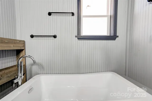 a white bath tub sitting next to a white toilet