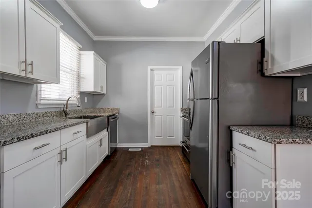 a kitchen with granite countertop a refrigerator stove and sink
