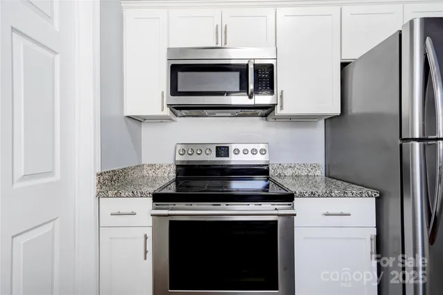 a kitchen with stainless steel appliances a stove microwave and refrigerator