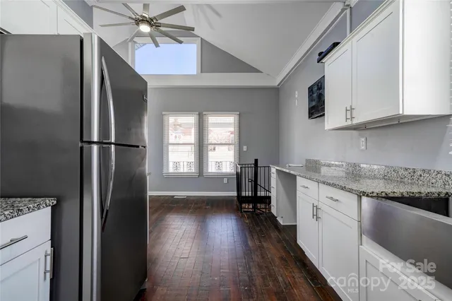 a kitchen with a refrigerator a sink and dishwasher with wooden floor