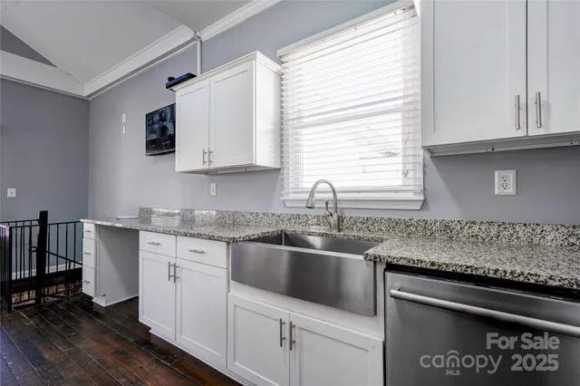 a kitchen with granite countertop a sink stove and cabinets
