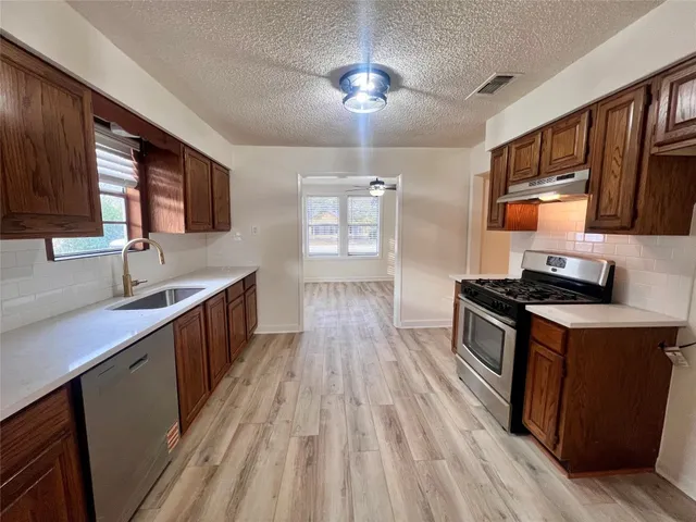 a kitchen with stainless steel appliances granite countertop a sink stove and refrigerator