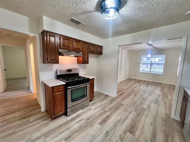 a kitchen with stainless steel appliances granite countertop a stove and a refrigerator