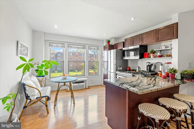 a dining room with furniture potted plants and wooden floor