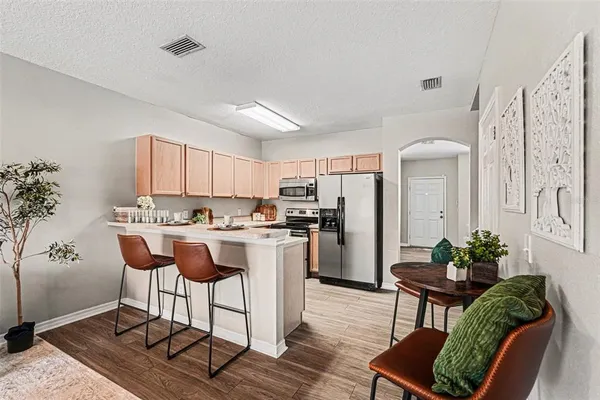 a kitchen with a refrigerator and table chair