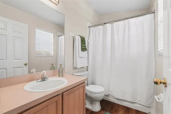 a bathroom with a granite countertop sink toilet and a mirror